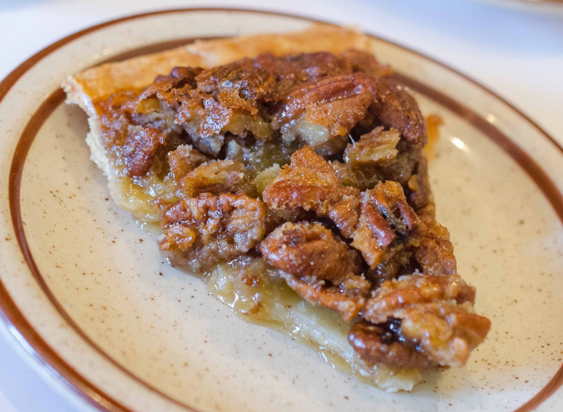 Slice of pecan pie on a white plate