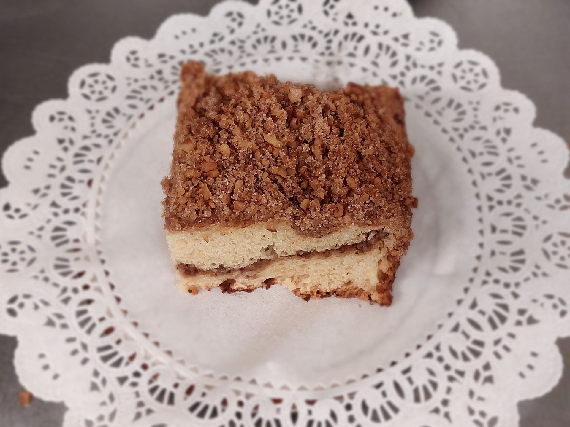 Slice of layered chocolate cake on a white lace doily plate
