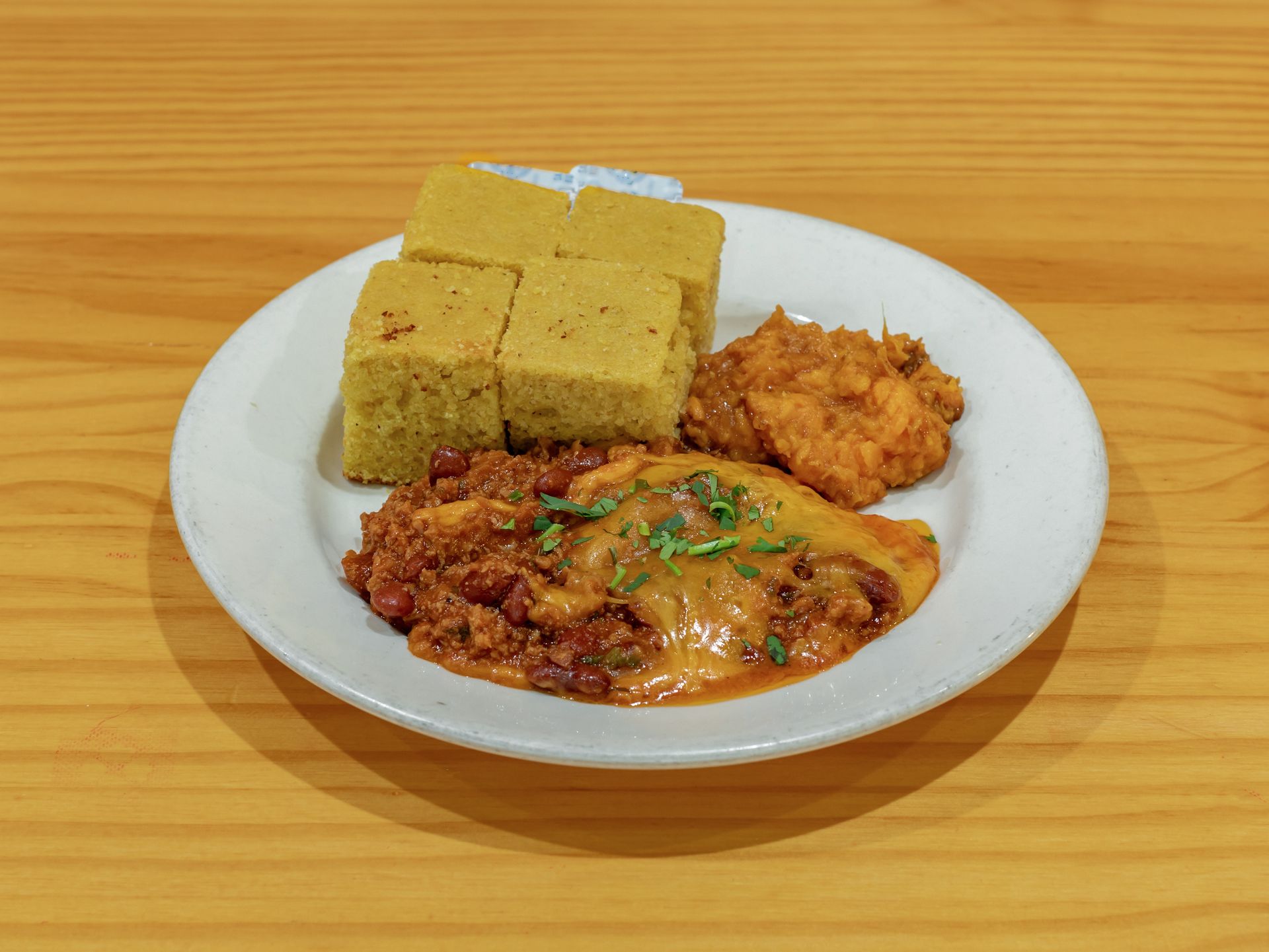 White plate with rice cakes and saucy stewed dishes on a wooden table
