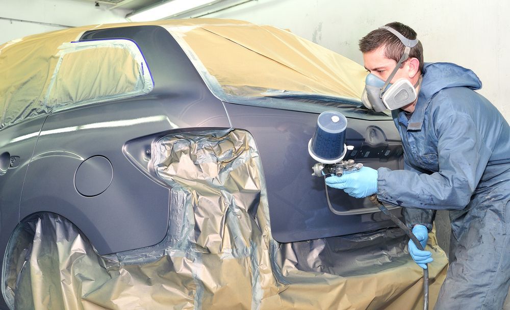 Person in Protective Gear Spray Painting a Car in a Shop — Bowen Automotive In Bowen, QLD
