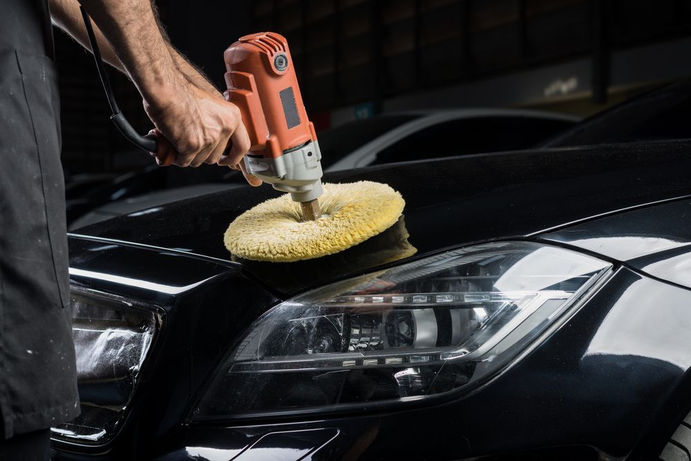 Man Polishing a Black Car With an Electric Buffer — Bowen Automotive in Bowen, QLD
