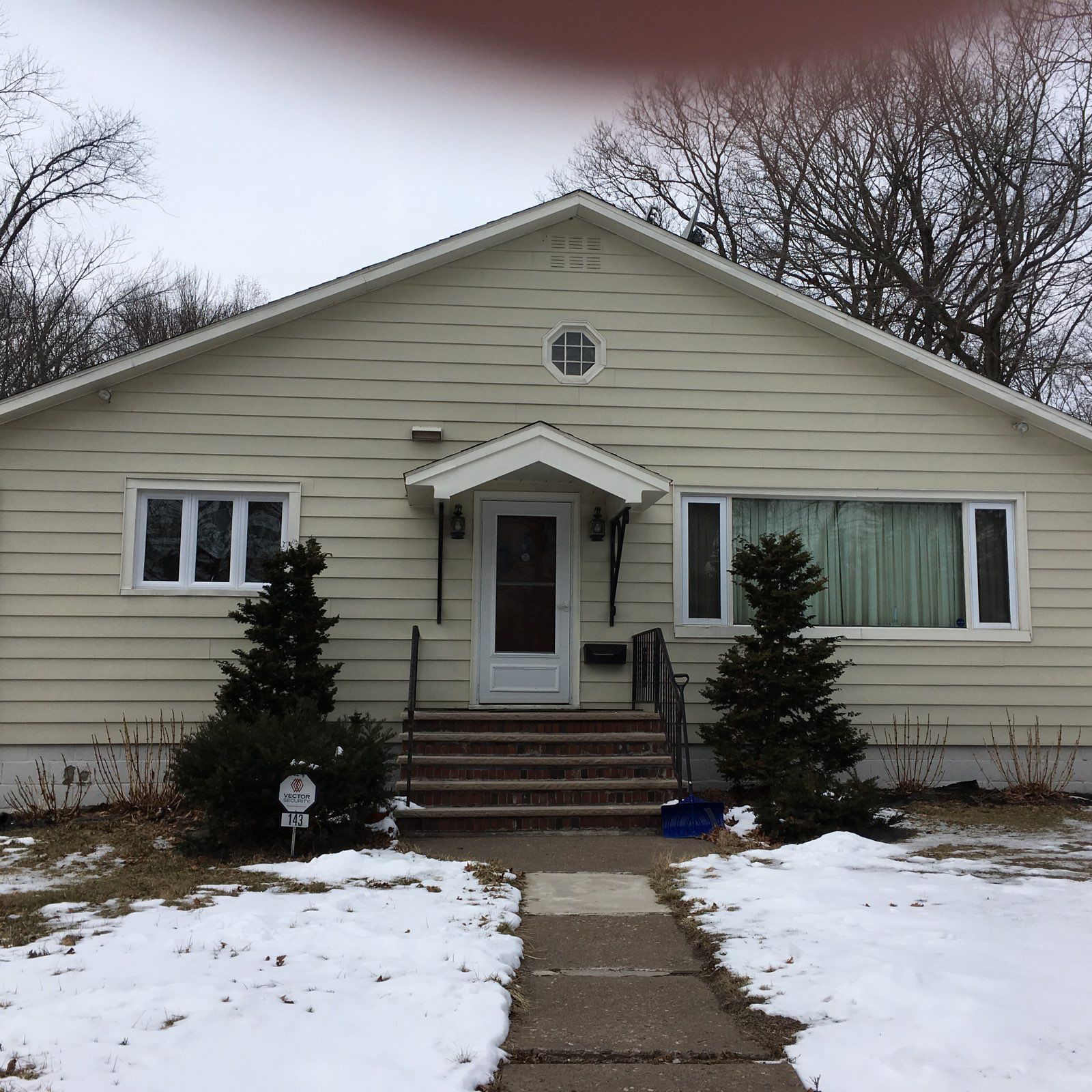 A house with snow on the ground in front of it