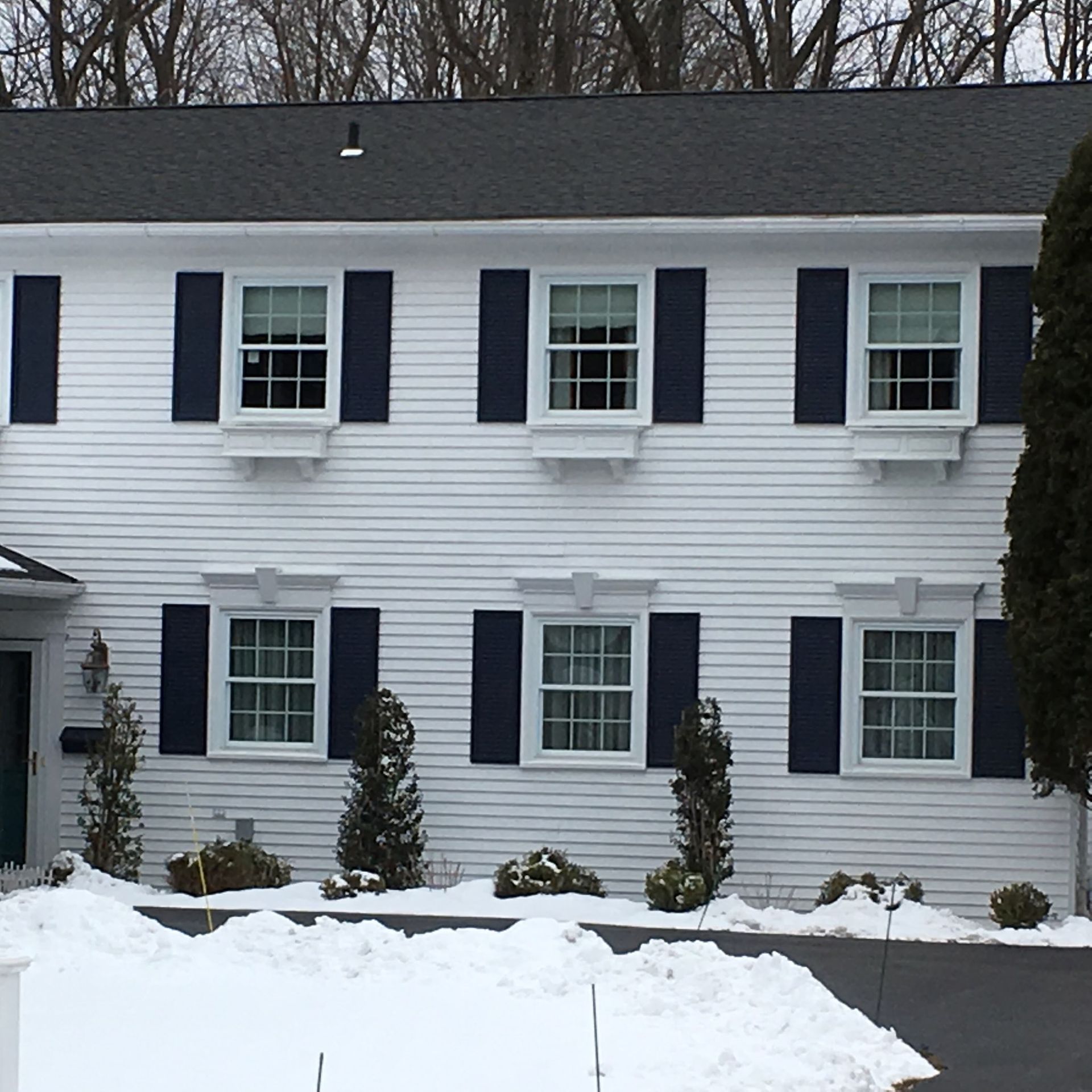 A white house with black shutters on the windows