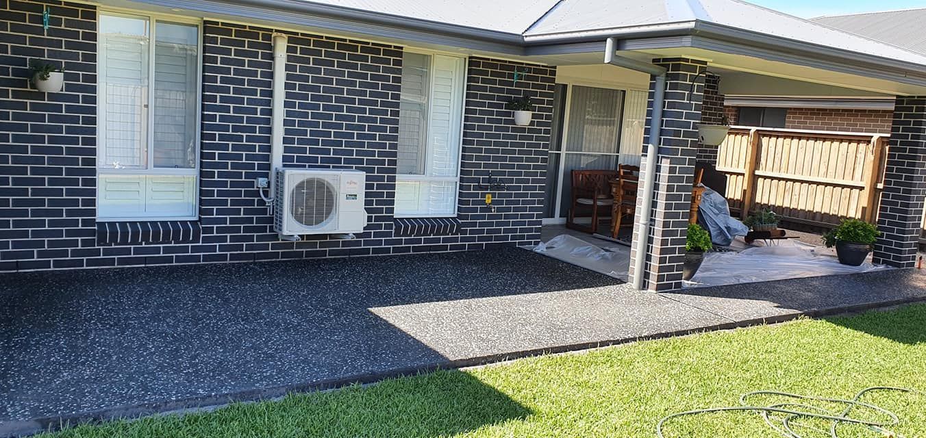 A brick house with a patio in front of it. — MidCoast Concreting in Mount George, NSW