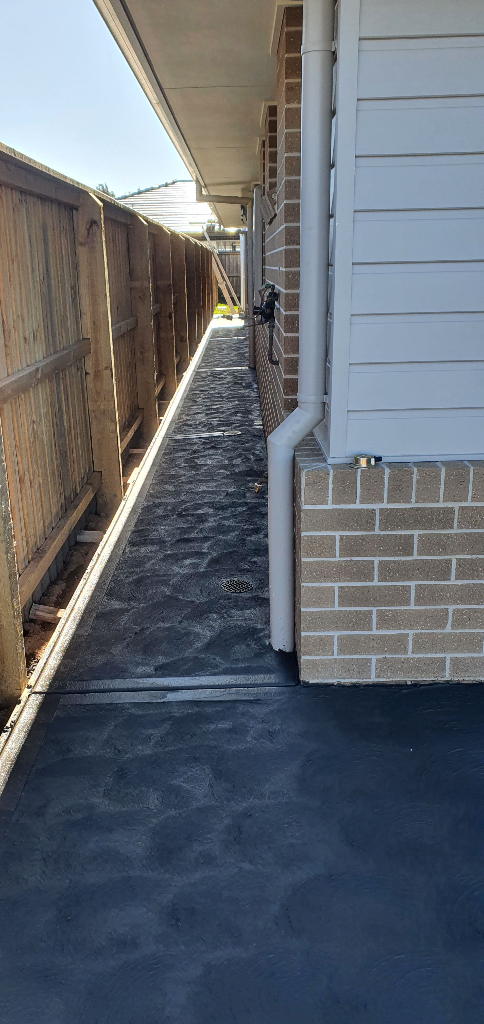 A sidewalk leading to the side of a house next to a fence. — MidCoast Concreting in Mount George, NSW