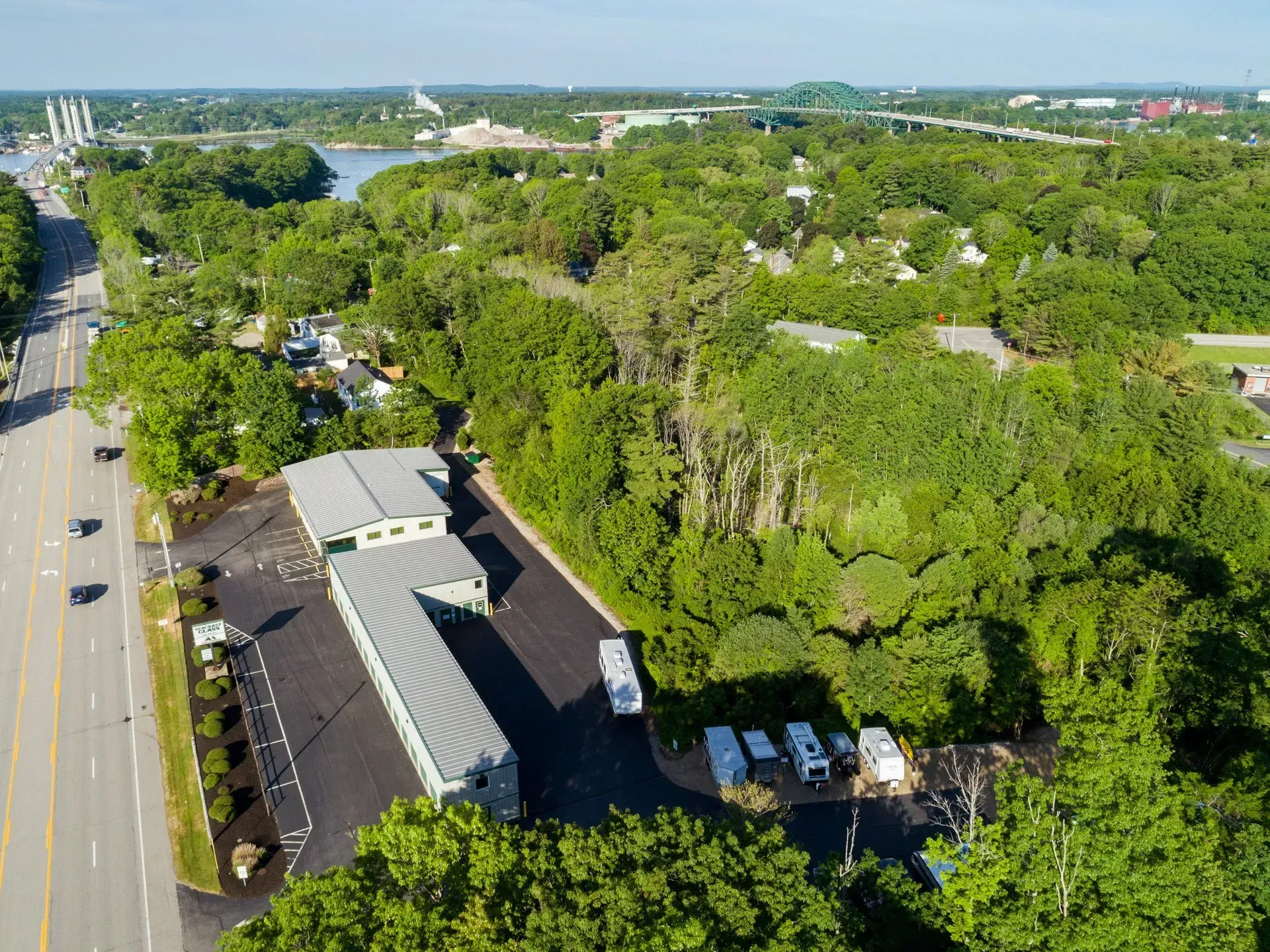 An aerial view of a motel surrounded by trees and a road.