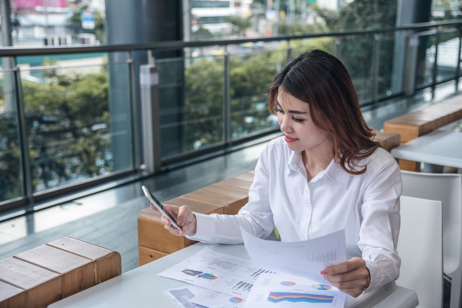 Business team reviewing financial chart, pointing to data on a paper.