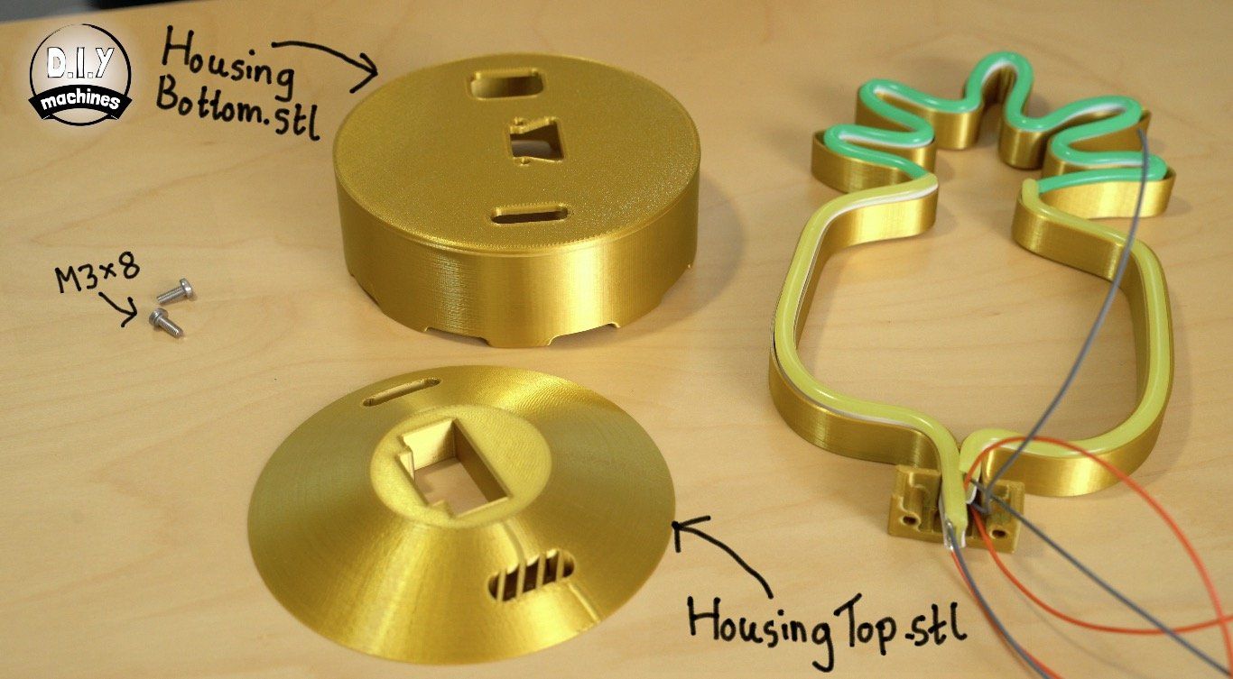 Three gold 3D-printed parts for a pineapple light fixture, including housing pieces and an LED neon pineapple frame.