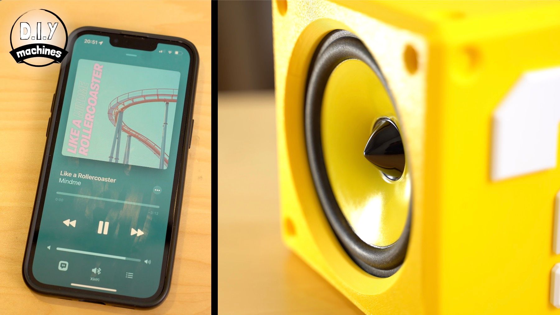 A yellow block-shaped speaker sits next to a smartphone displaying a music player interface on a wooden surface.