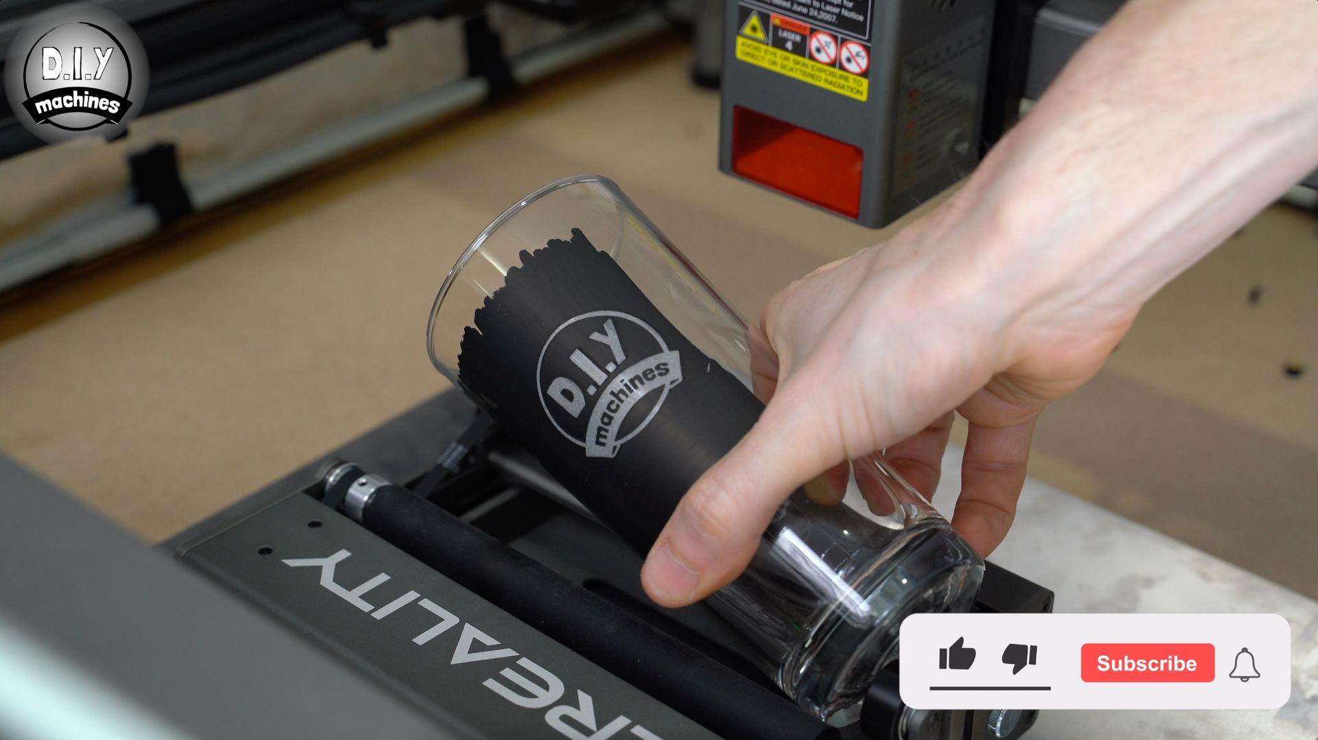 A hand placing a glass engraved with a