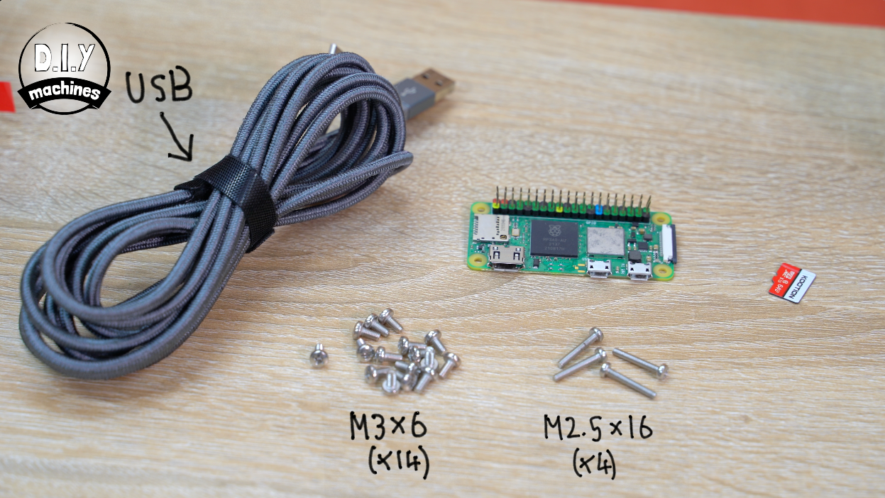 Components for a DIY electronics project including a gray USB cable, a Raspberry Pi Zero, SD card, and sets of small screws.