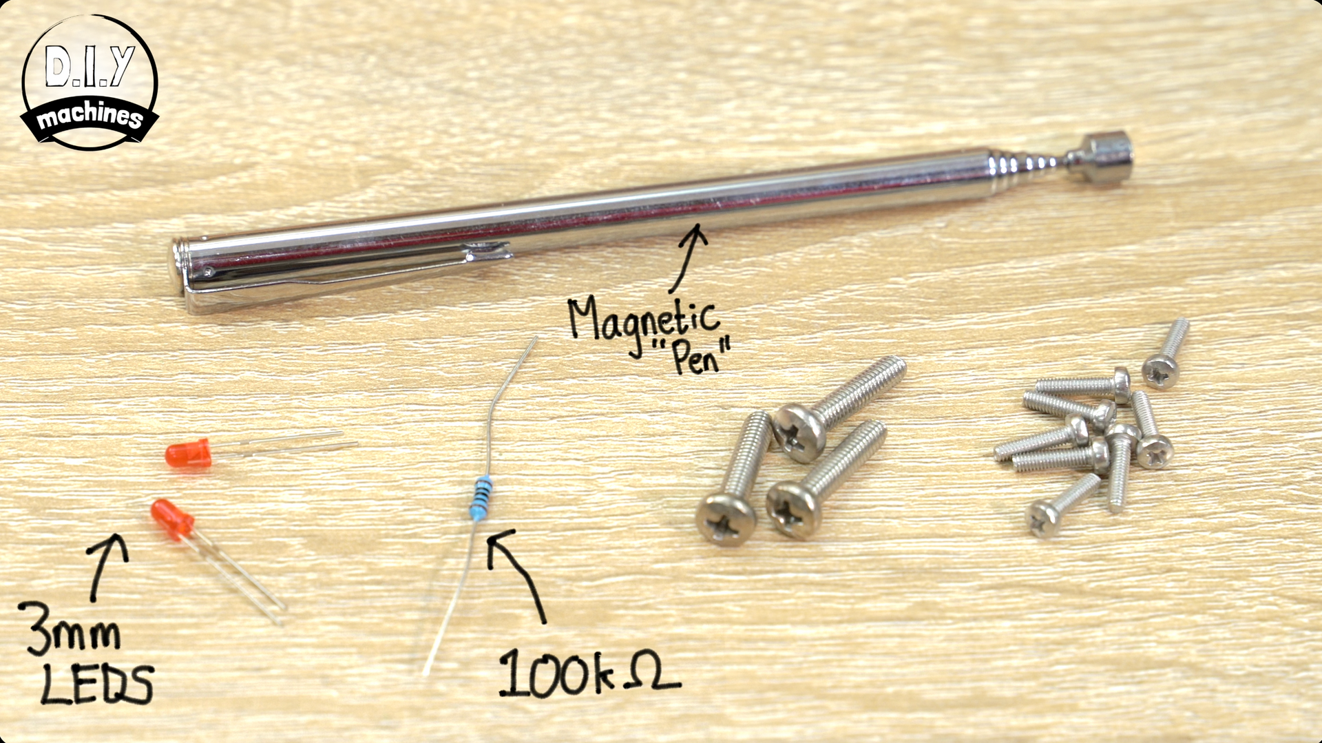 A workspace featuring a telescoping magnetic pen, two 3mm LEDs, a 100kΩ resistor, and a small assortment of screws.