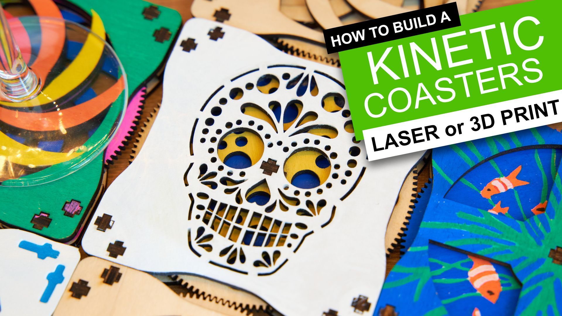 DIY kinetic coasters in various designs, including a white sugar skull and a blue fish pattern, on a wooden surface.
