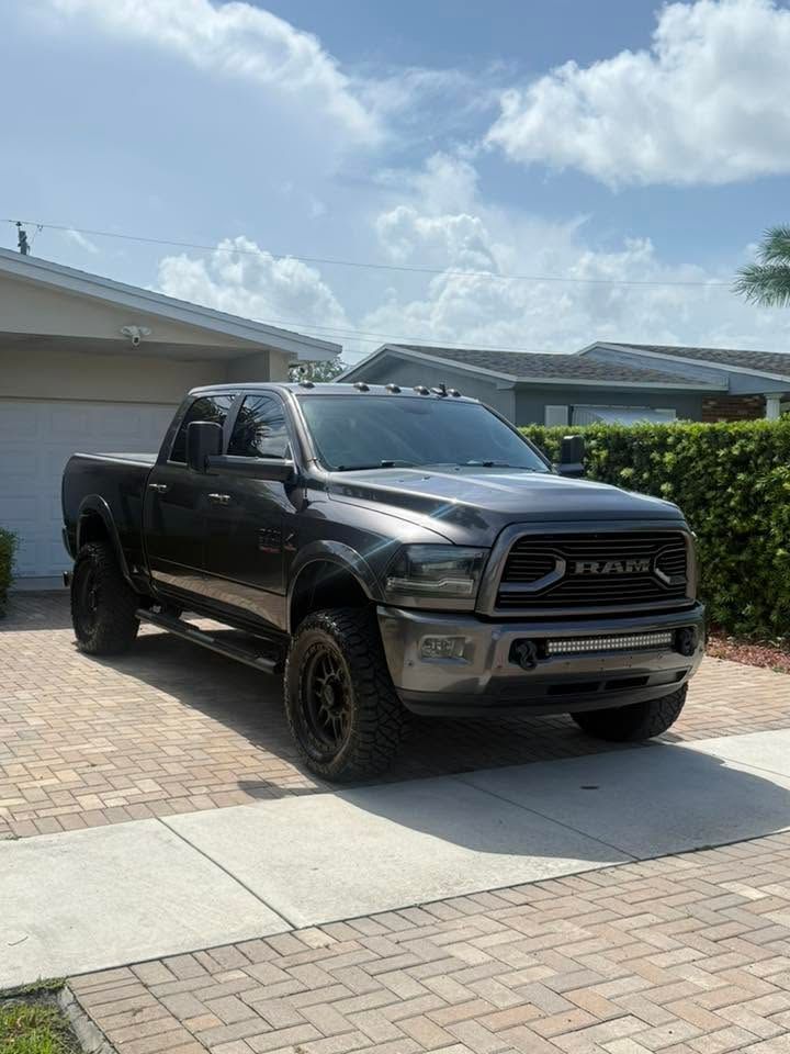 Black RAM pickup truck parked in a driveway under a bright blue sky