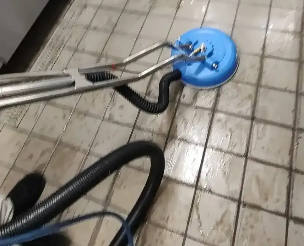 Precise Deep Cleaning technician running Power-Scrub hot water extraction equipment on a commercial kitchen tile floor