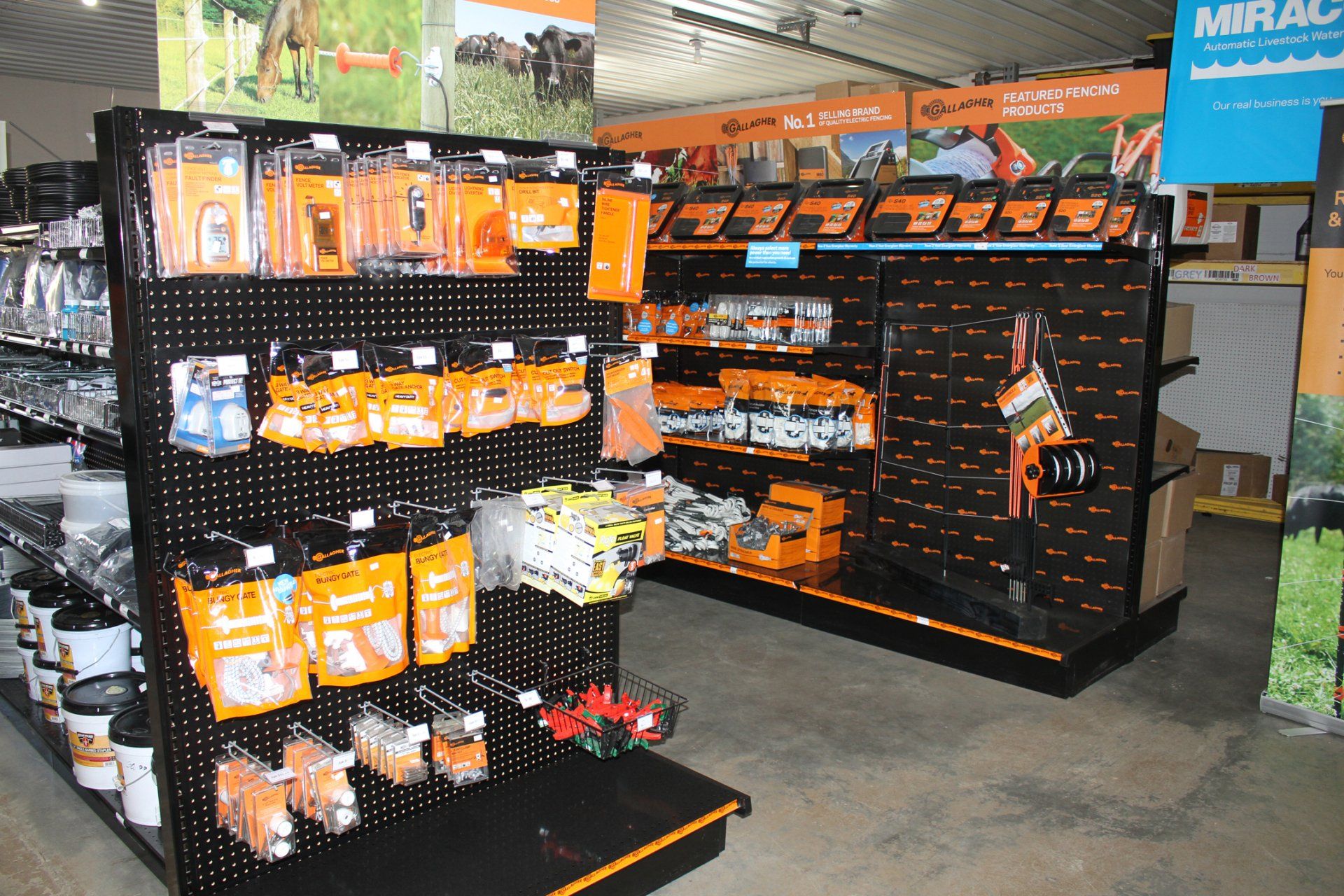 Shelves stocked with orange and black packaged tools inside a store.