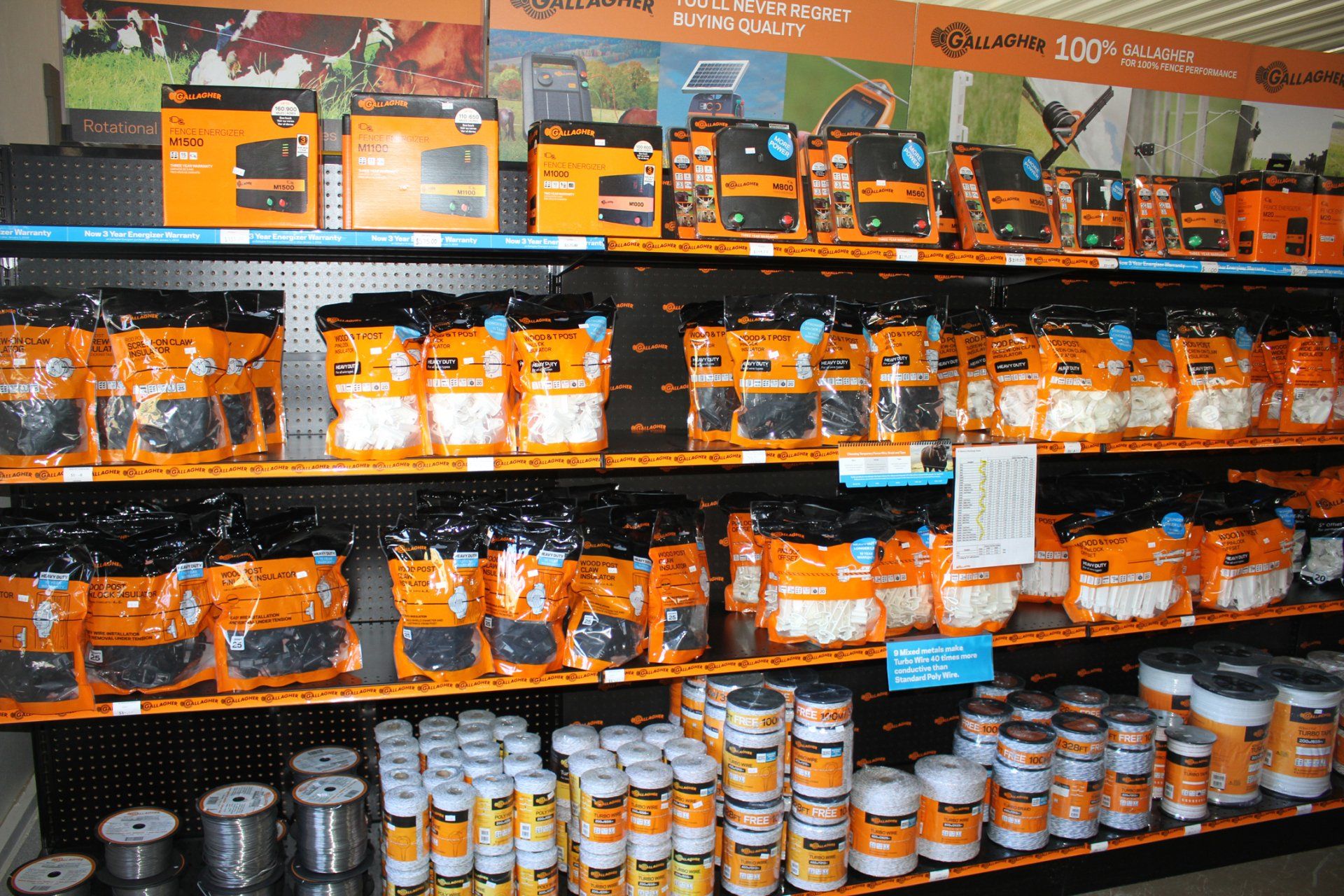 Shelves displaying various orange and black packaged items in a store; products for sale.