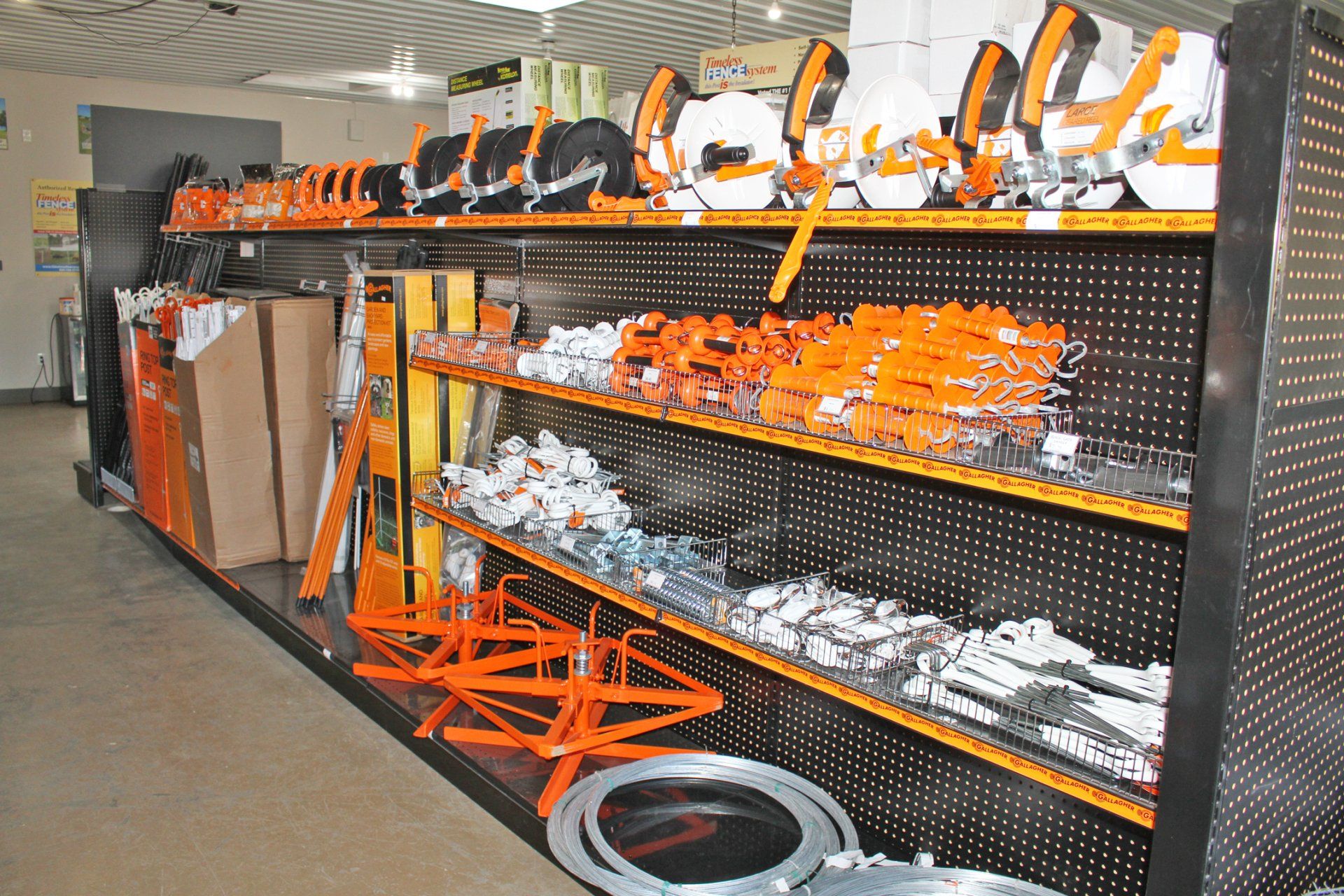 Shelves stocked with orange and silver hardware in a store.