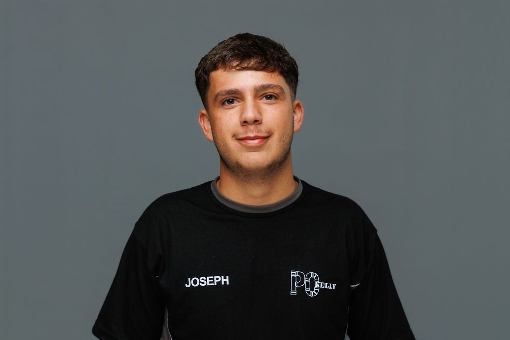 Portrait of a person in a black shirt against a gray background