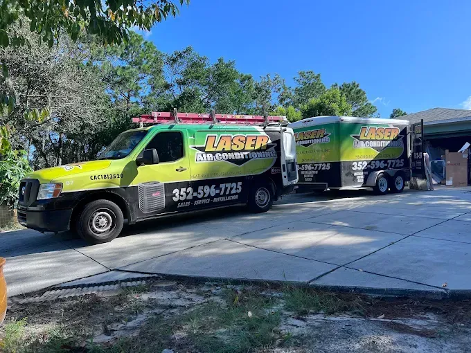 Laser Air Conditioning Service truck and trailer parked on a driveway.