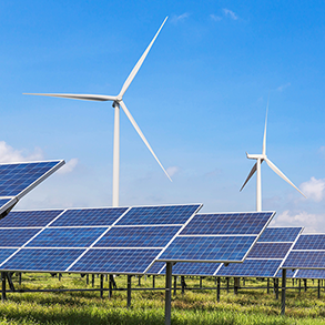 Solar panels in front of wind turbines under a blue sky, showcasing renewable energy.