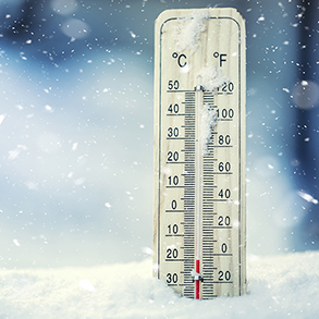 Thermometer in snow, displaying below-freezing temperatures in both Celsius and Fahrenheit scales.