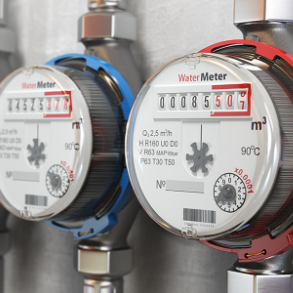 Two water meters with digital displays, one with a blue ring and one with a red ring, mounted on pipes.