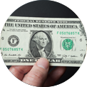 Hand holding a one-dollar bill with George Washington's portrait.