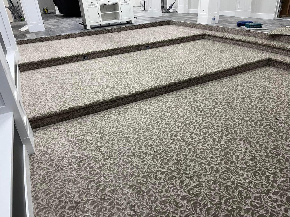 Patterned carpeted indoor ramp with dark wooden rails on a sloped floor