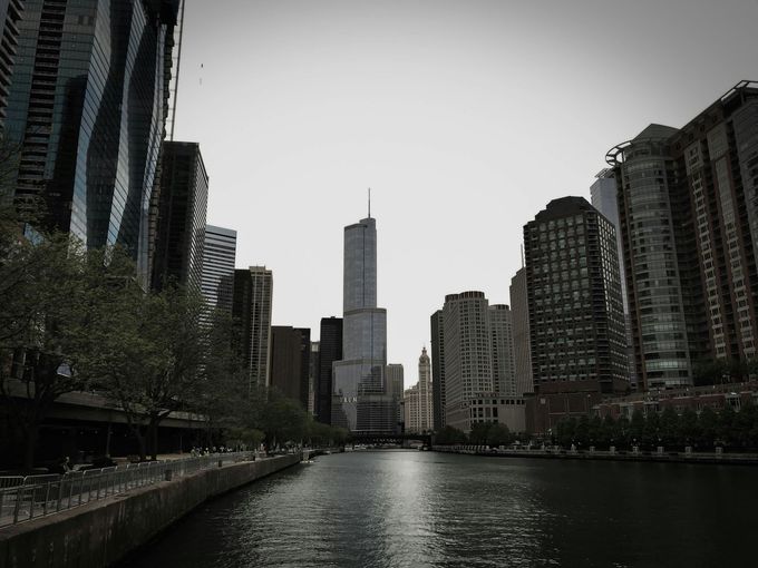 City river canal lined with tall buildings, viewed under a gray sky