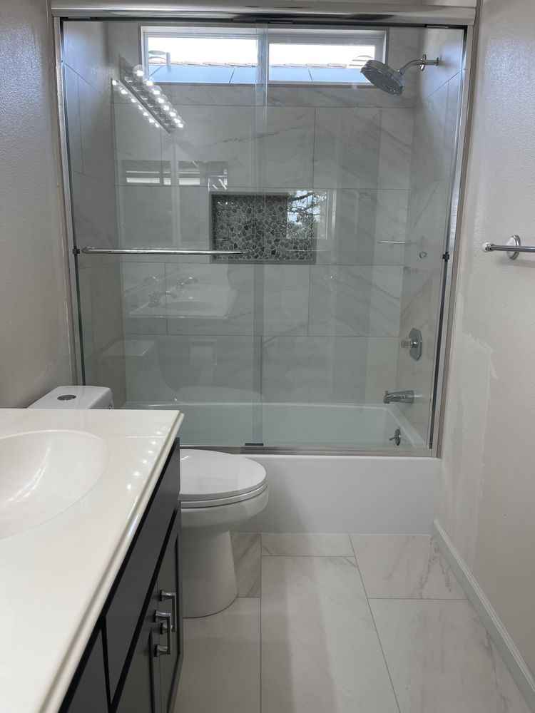 A bathroom with a toilet , sink , tub and shower.