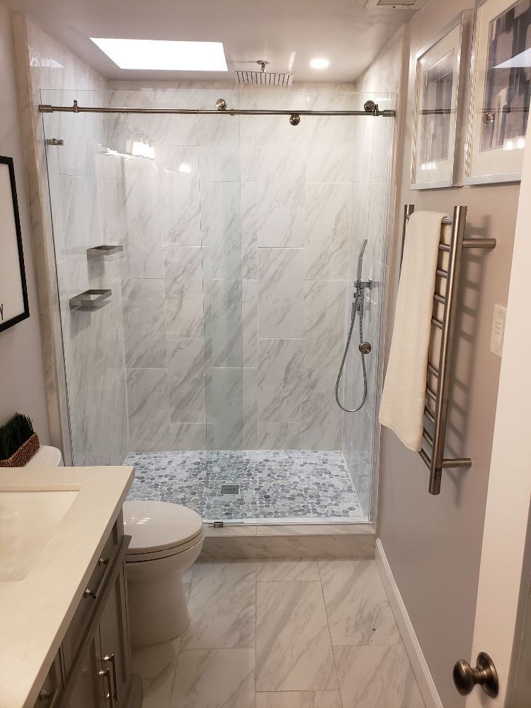 A bathroom with a toilet , sink , and walk in shower.