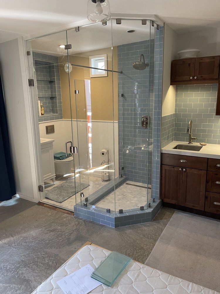 A bathroom with a walk in shower and a sink.