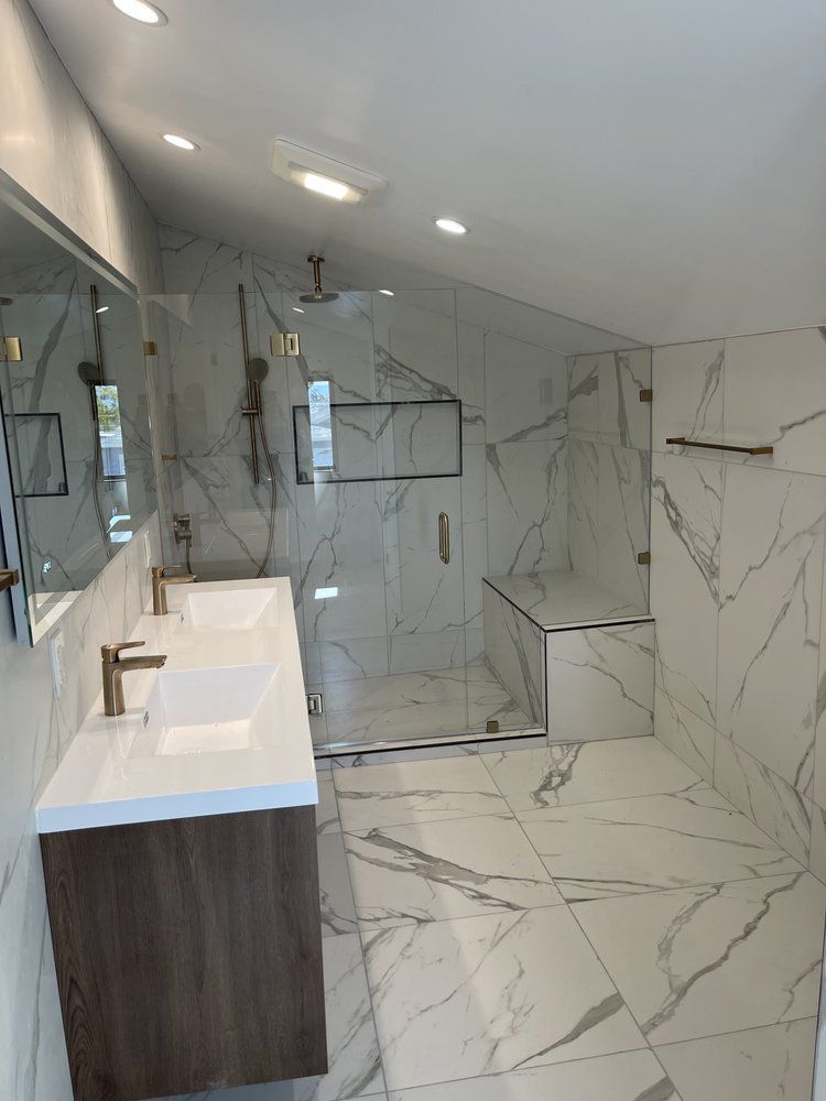 A bathroom with two sinks and a walk in shower.