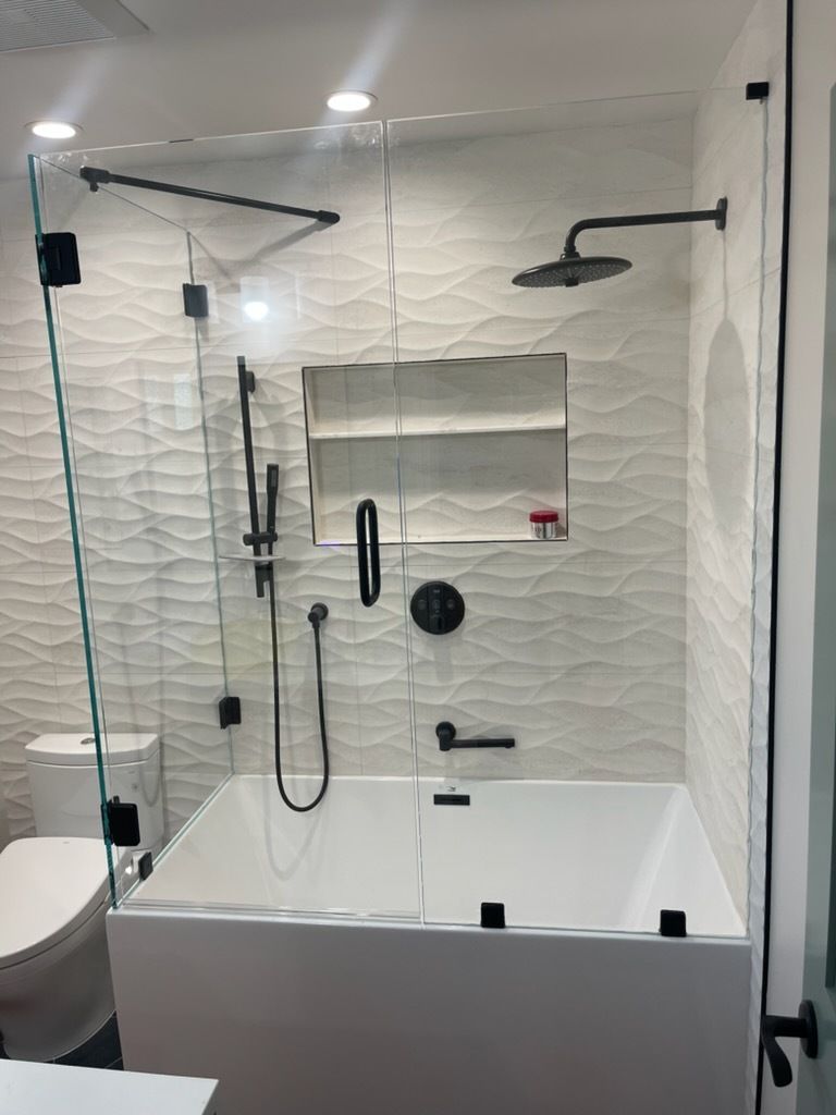 Modern white-tiled bathroom with a bathtub, handheld shower, grab bars, and shower curtain rod