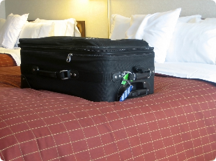 A suitcase is sitting on a bed in a hotel room