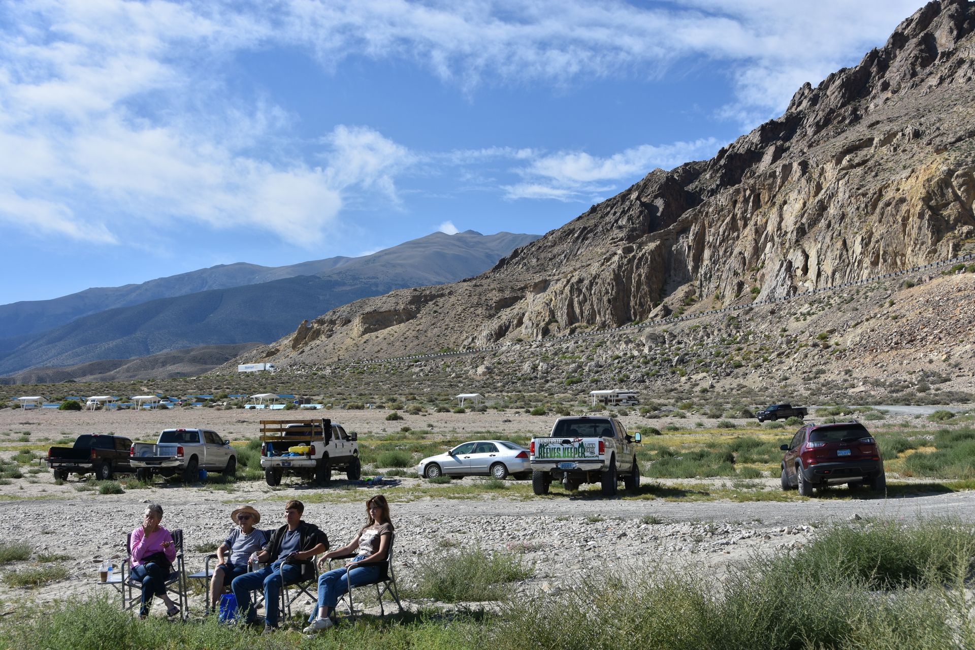 A group of people are sitting in chairs in front of a mountain.