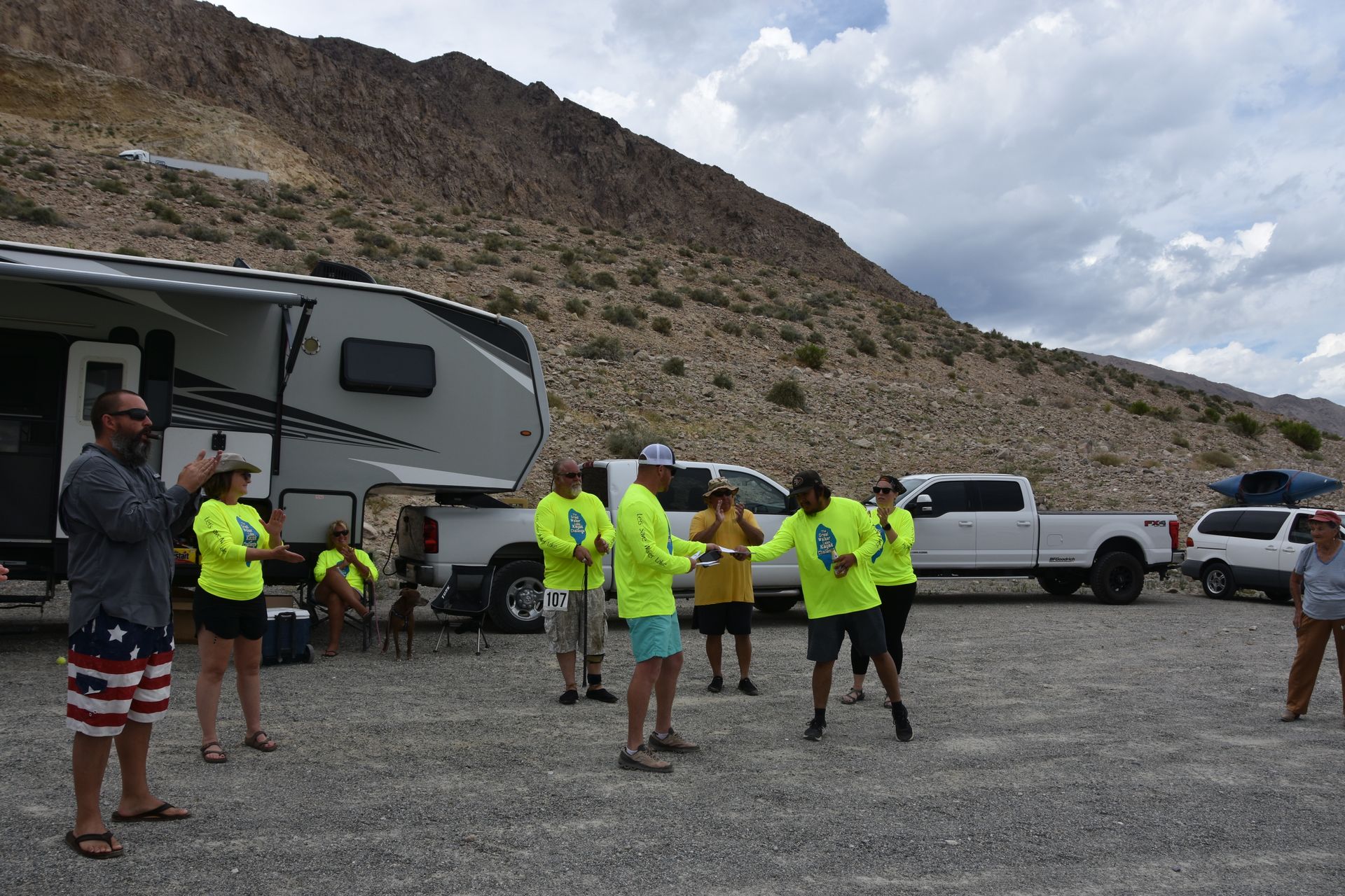 A group of people are standing in front of a rv.