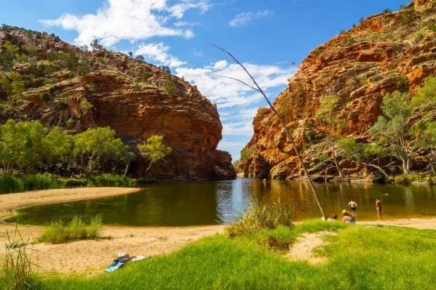 A Group of People are Sitting on the Shore of a River — Alice Springs Podiatry in Ciccone, NT