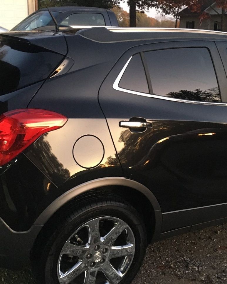 a black car is parked in front of a house