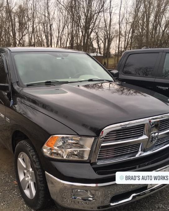 a black dodge ram truck is parked in a parking lot .