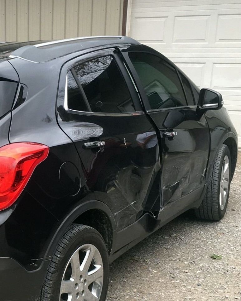 a black car is parked in front of a garage door .