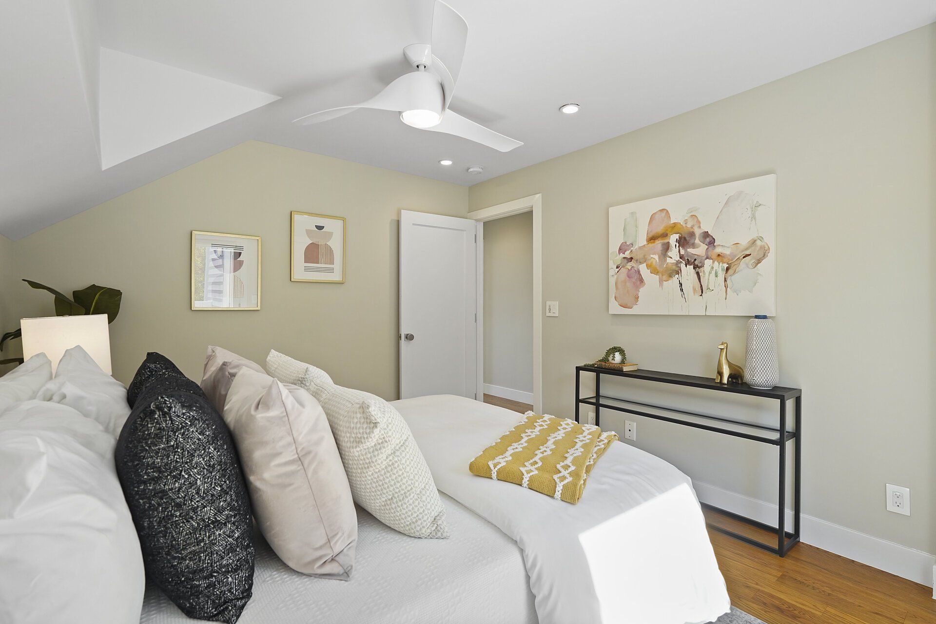A bedroom with a bed and a ceiling fan.