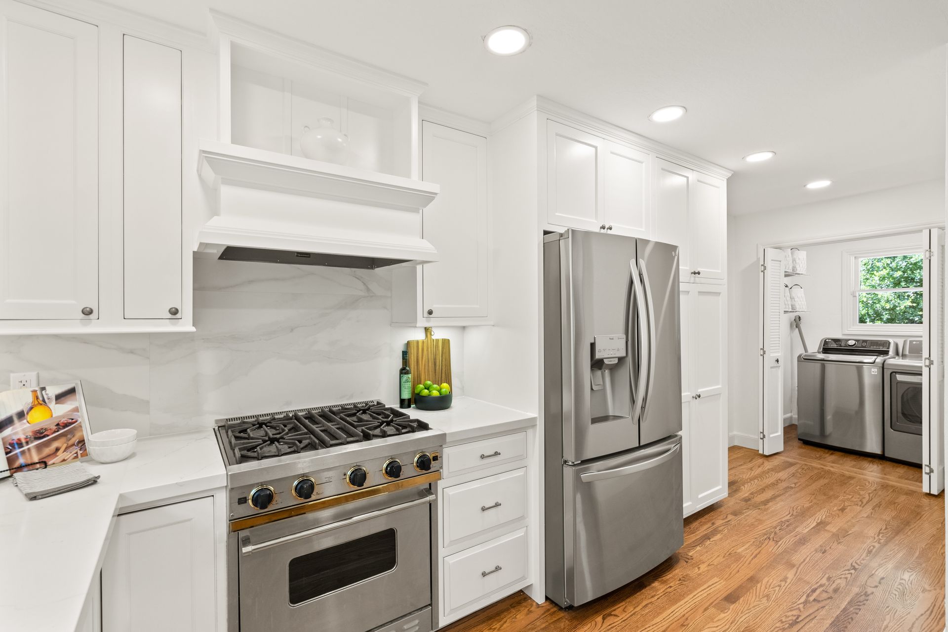 A kitchen with stainless steel appliances and white cabinets.