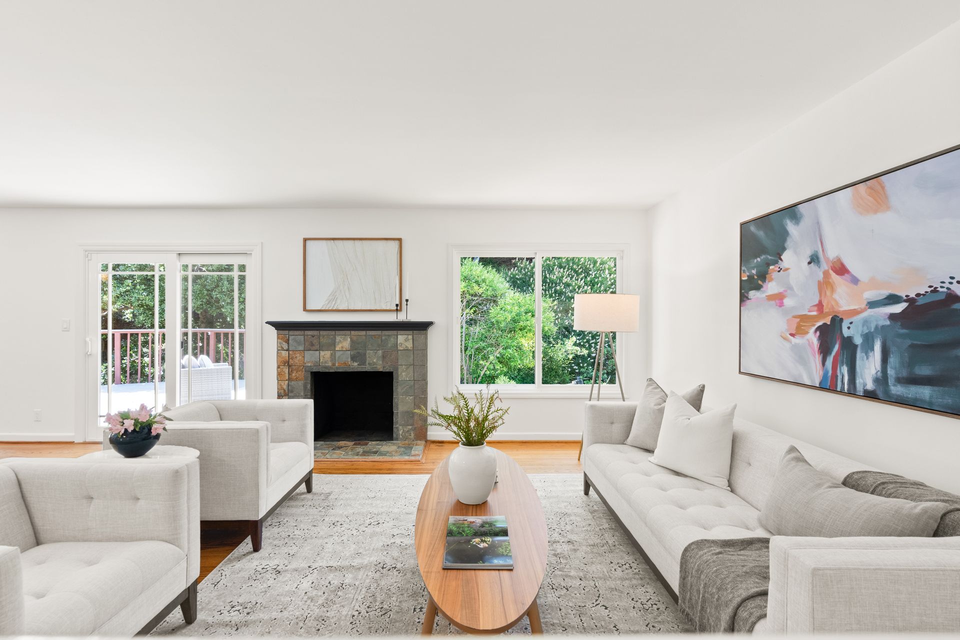 A living room with white furniture and a fireplace.