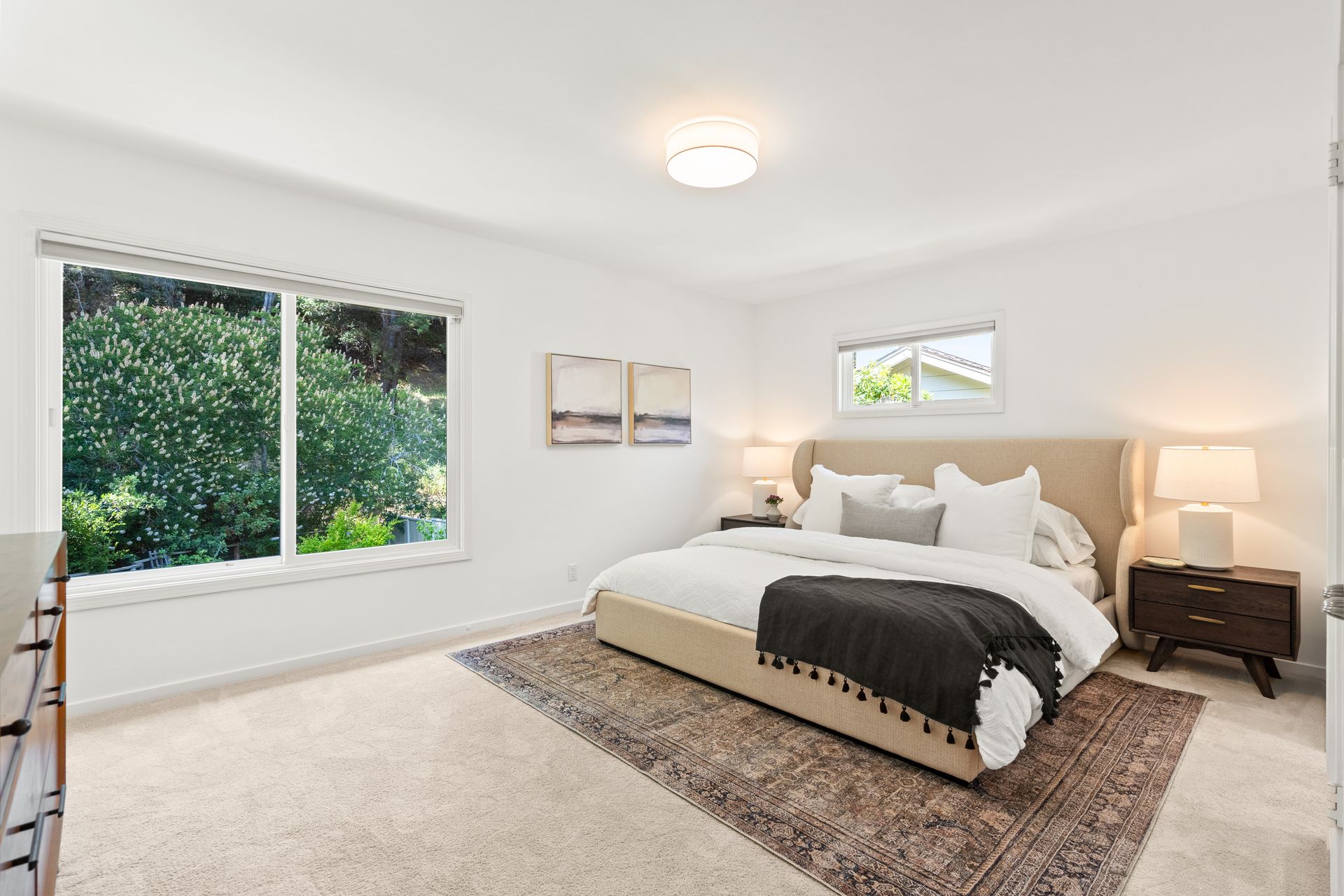 A bedroom with a bed , two windows and a rug.