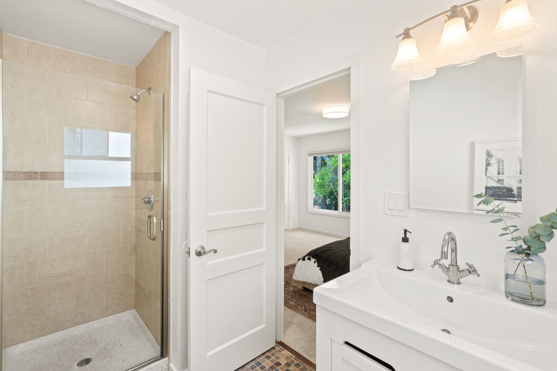 A bathroom with a sink and a walk in shower.