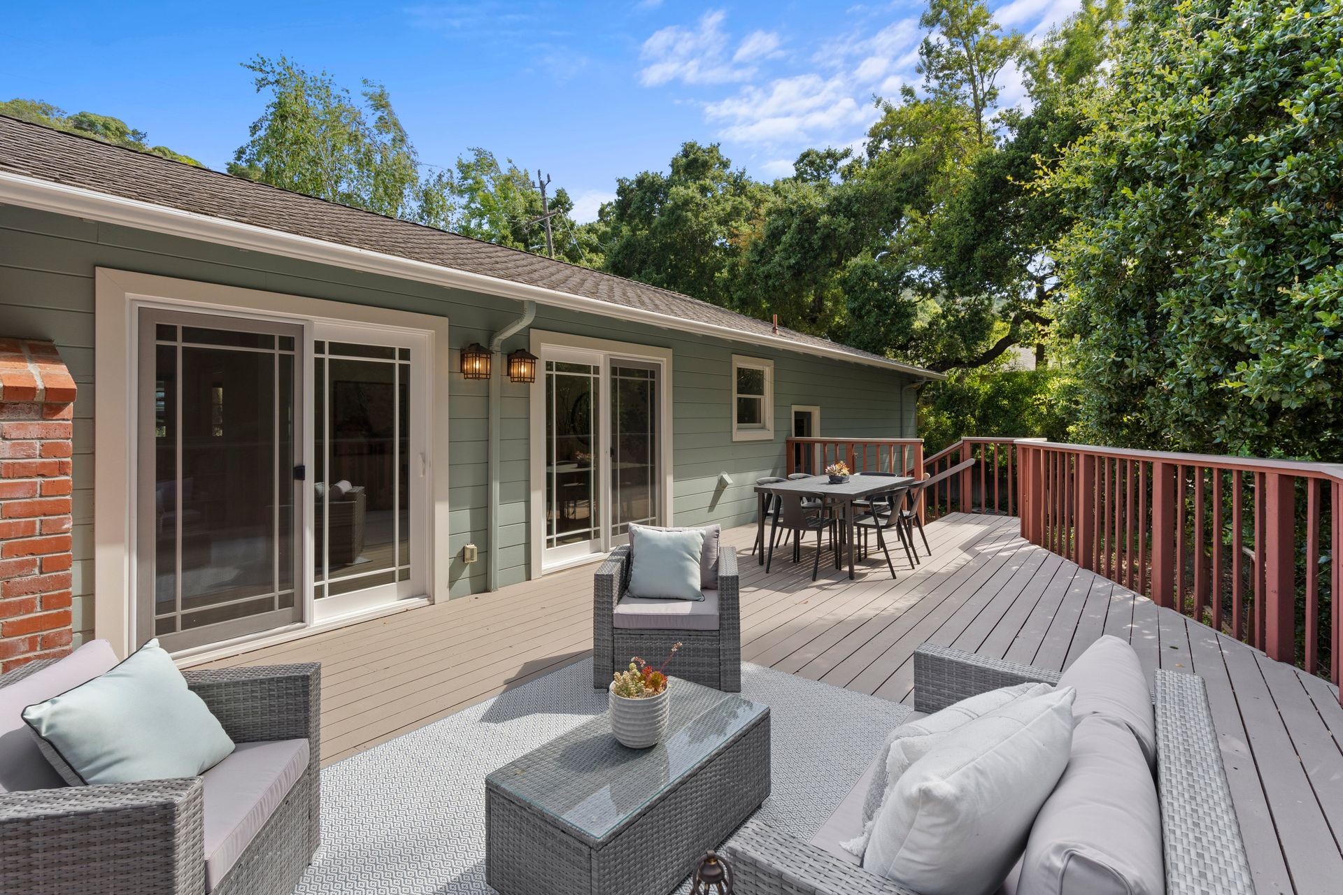 There is a large deck with a table and chairs on it.