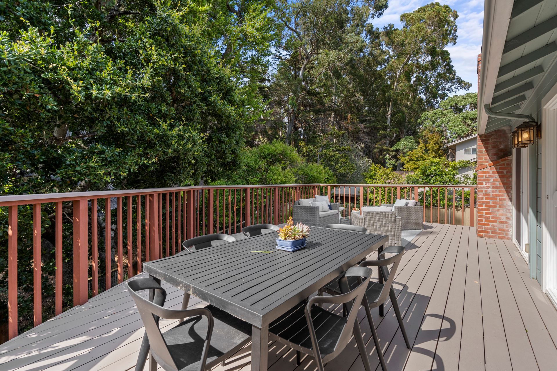 There is a large deck with a table and chairs on it.
