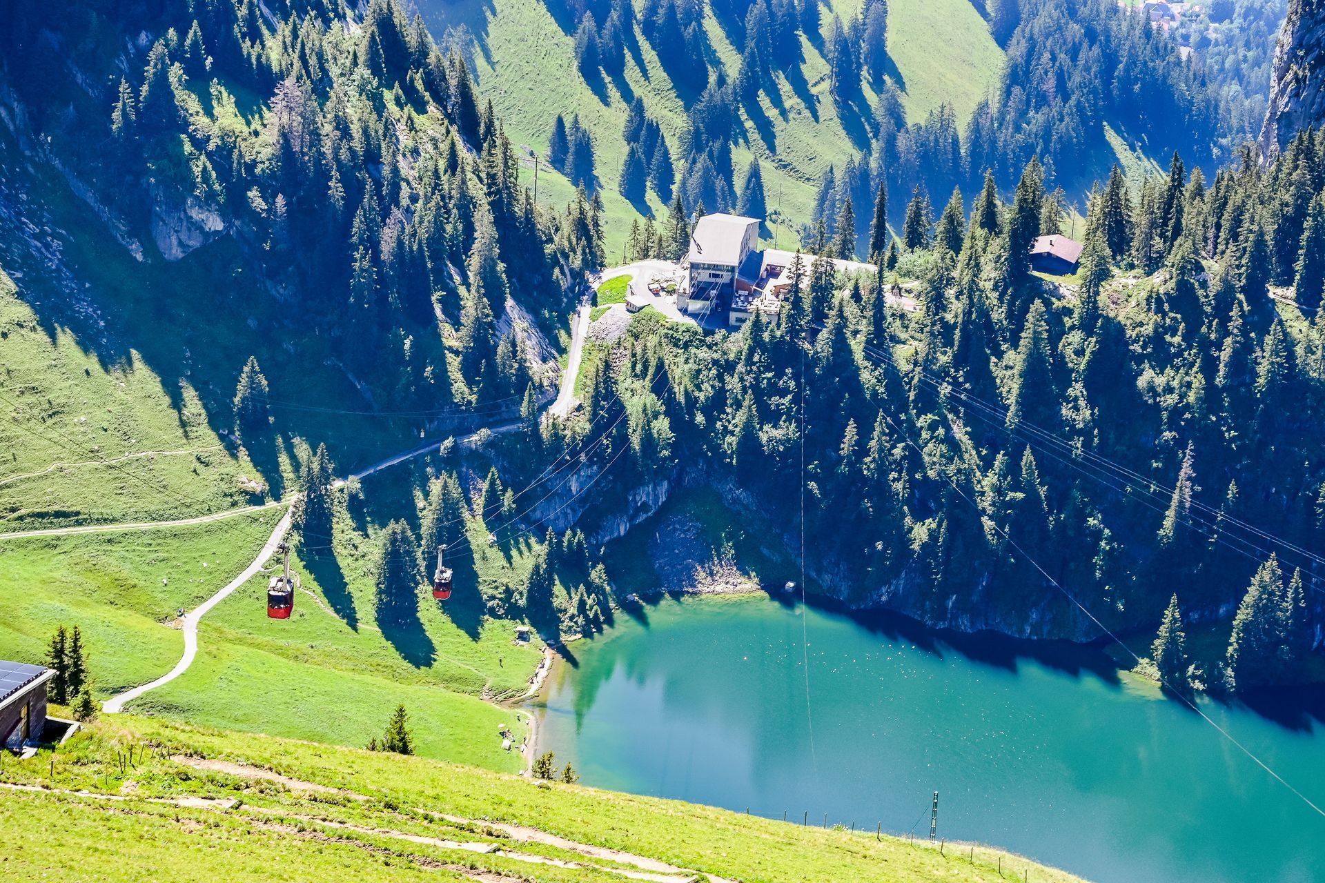 An aerial view of a lake surrounded by mountains and trees